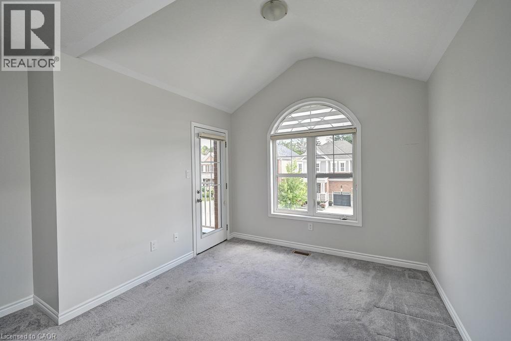 Vaulted ceiling, arched window with horizontal blinds, glass panel door, gray carpeting, and white trim - 236 Ridge Road, Cambridge, ON