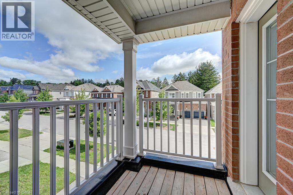 Balcony with wood-finish flooring, white railing, and brick wall - 236 Ridge Road, Cambridge, ON