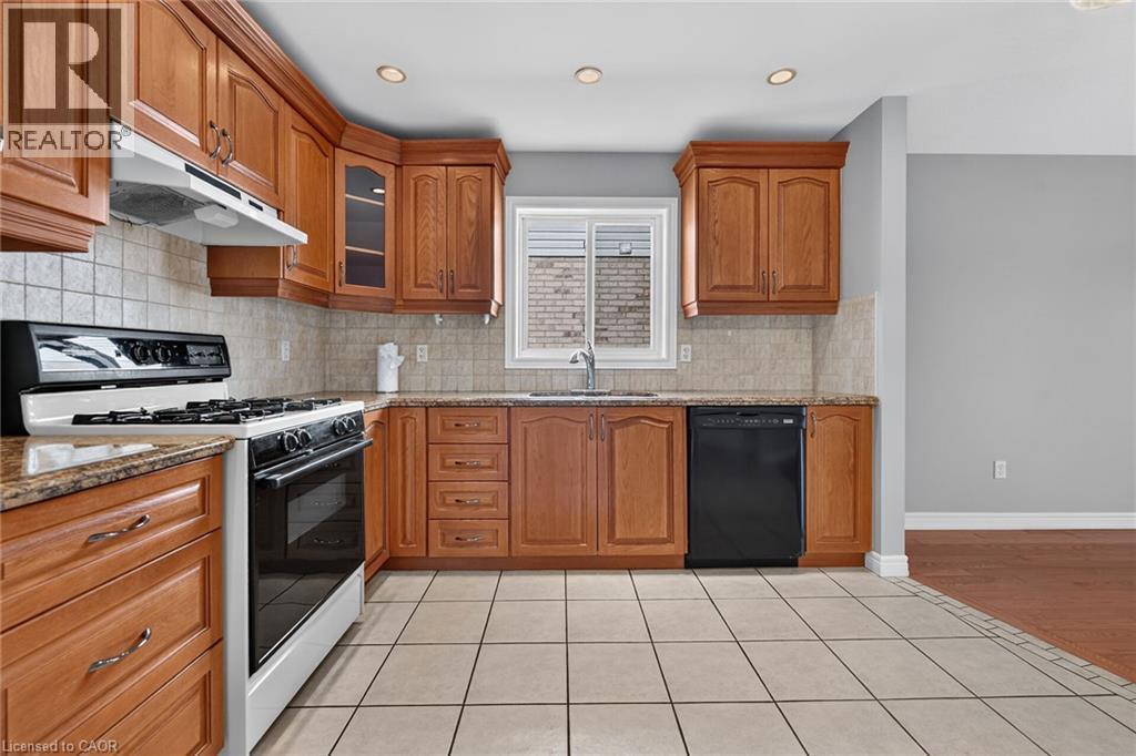 Kitchen featuring wood cabinetry, light-toned tile flooring, recessed lighting, and a window above the sink - 795 Tenth Avenue, Hamilton, ON
