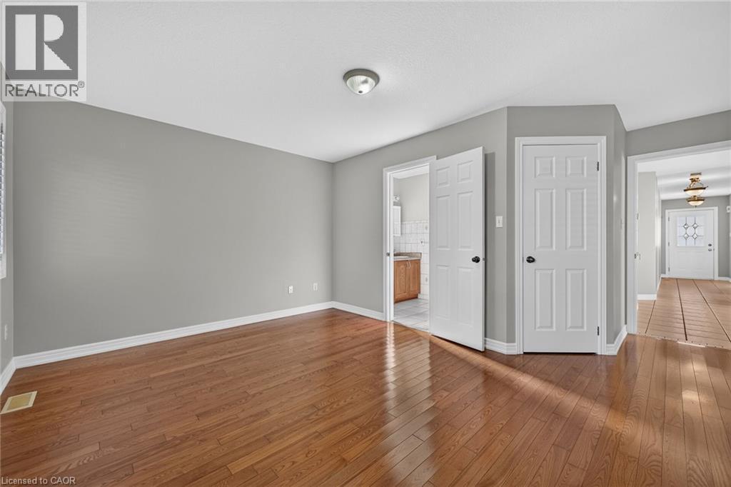 Wood-finish flooring throughout, neutral wall tones, and white paneled doors - 795 Tenth Avenue, Hamilton, ON