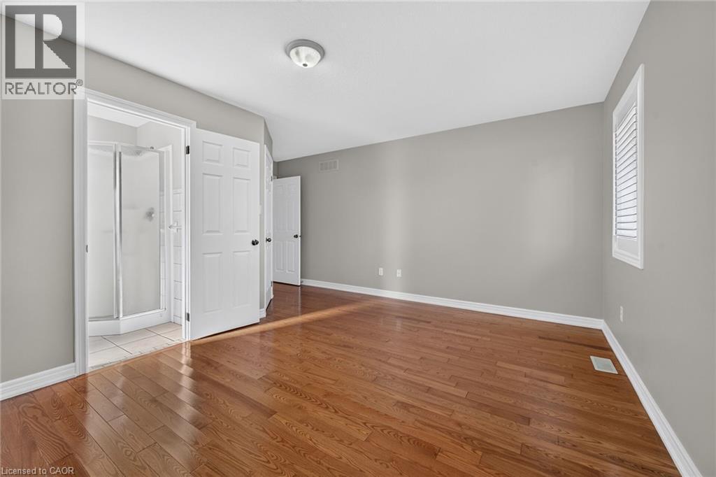 Hardwood flooring throughout, neutral gray wall tones, and a window with white shutters - 795 Tenth Avenue, Hamilton, ON