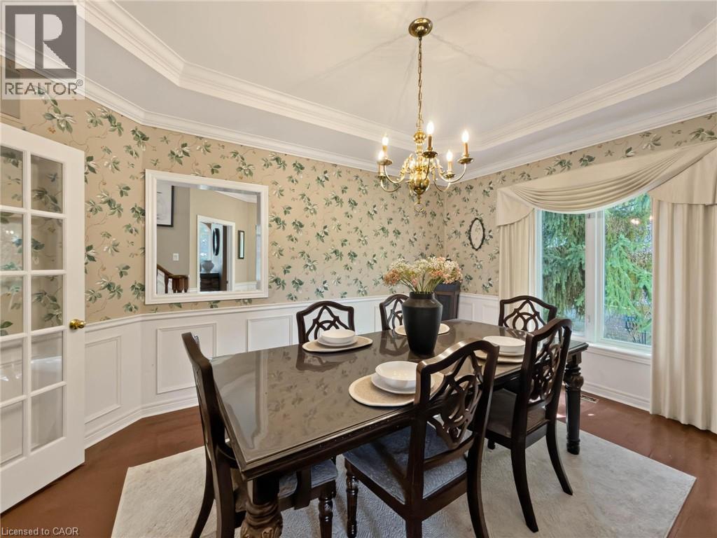 Tray ceiling with crown molding, decorative wallpaper, wainscoting, wood-finish flooring, and a multi-pane window - 74 Davidson Boulevard, Dundas, ON