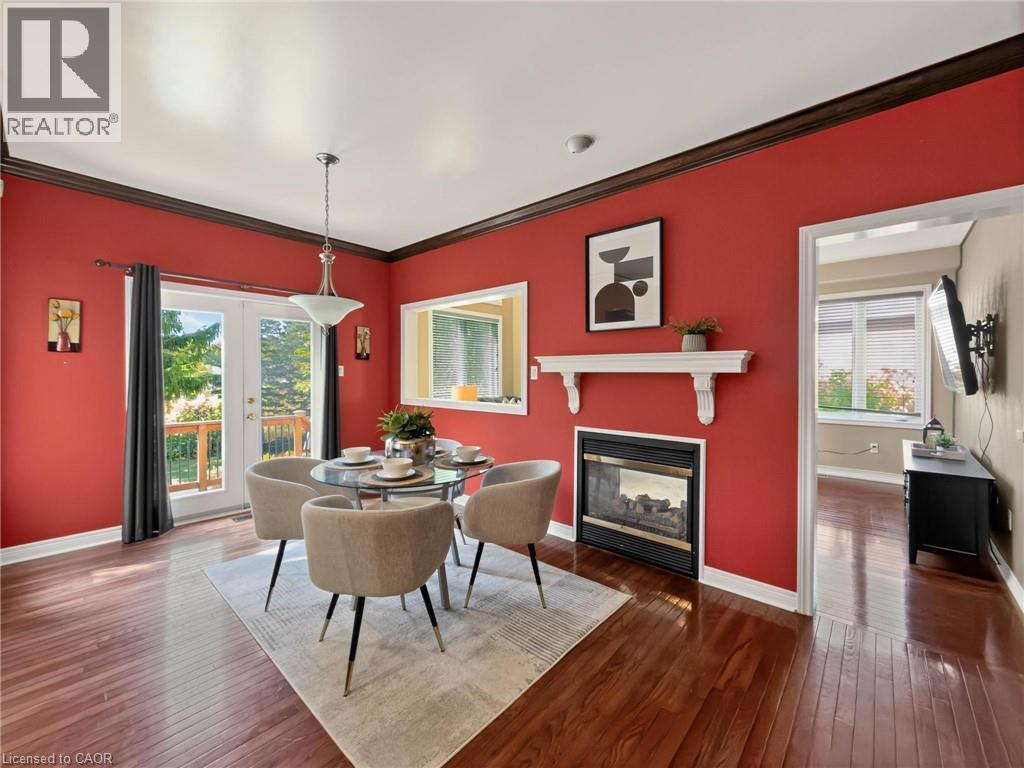 Hardwood flooring, crown molding, double French doors with outdoor access, built-in fireplace, and a pass-through window - 74 Davidson Boulevard, Dundas, ON