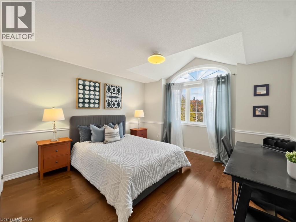 Vaulted ceiling with an arched window, wood-finish flooring, and crown molding details - 74 Davidson Boulevard, Dundas, ON