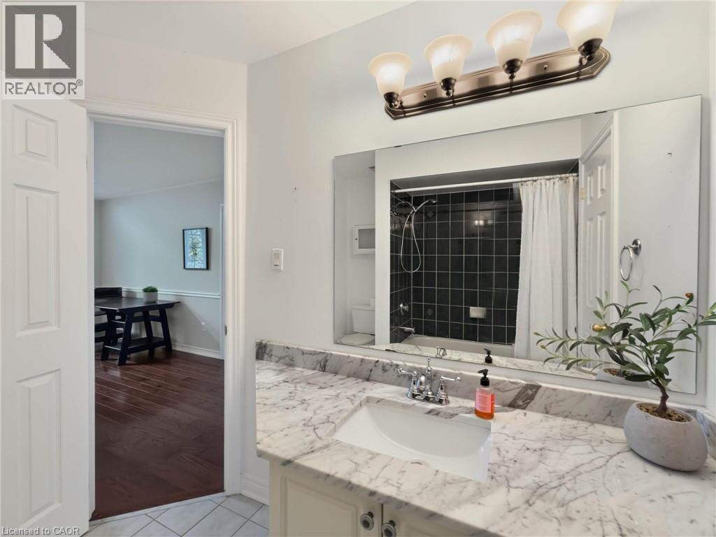 Vanity with a white rectangular sink, stone-finish countertop, and chrome faucet - 74 Davidson Boulevard, Dundas, ON