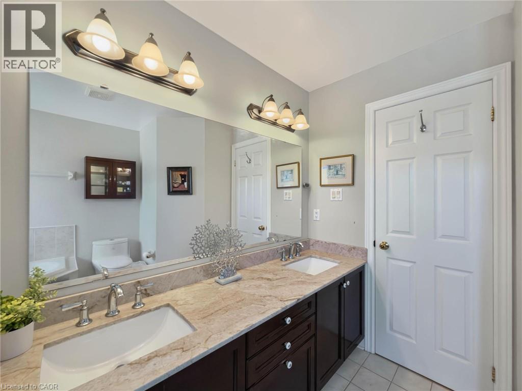 Dual vanity with integrated sinks, brushed nickel fixtures, and a spacious framed mirror - 74 Davidson Boulevard, Dundas, ON