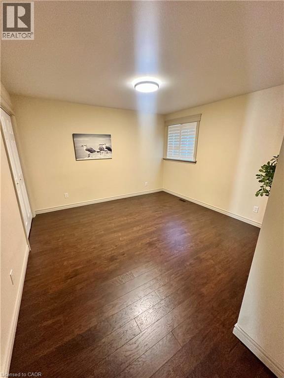 Wood-finish flooring, recessed lighting, and a window with plantation shutters - 5 Arden Avenue, Hamilton, ON