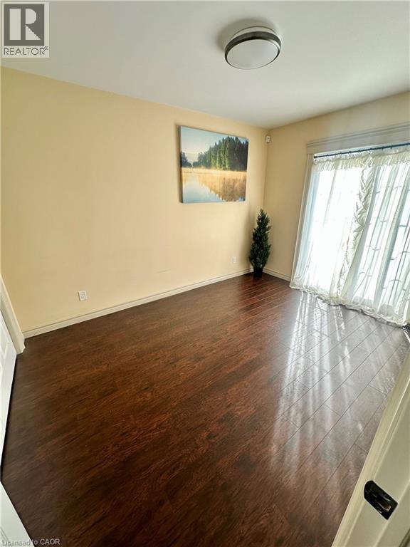Recessed lighting, wood-finish flooring, sliding glass door with privacy sheers, and neutral wall tones - 5 Arden Avenue, Hamilton, ON