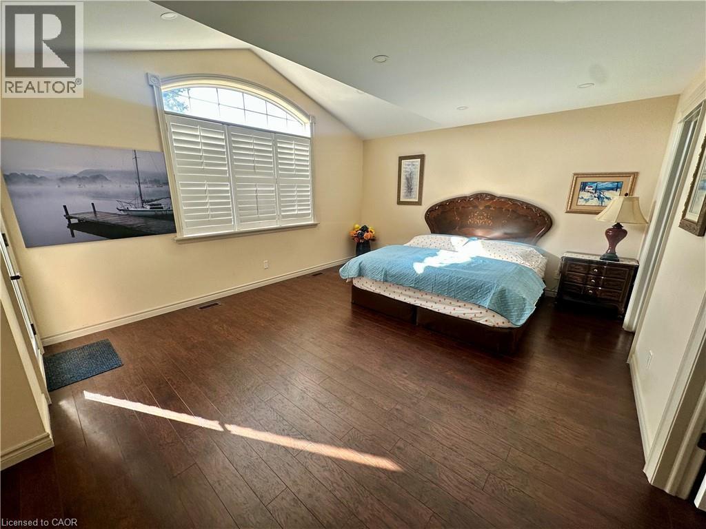 Arched window with plantation shutters, wood-finish flooring, recessed lighting, and sloped ceiling - 5 Arden Avenue, Hamilton, ON