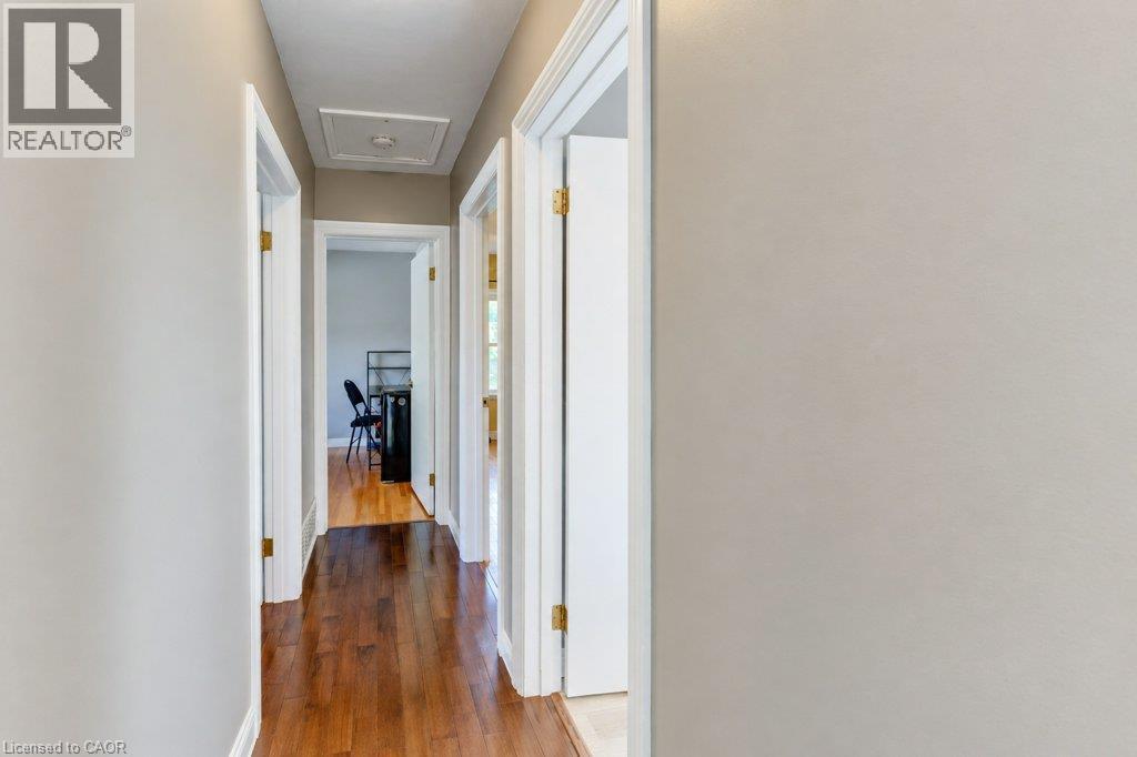 Hallway with wood-finish flooring, white trim, and light-toned walls - 34 Wayne Drive, Kitchener, ON