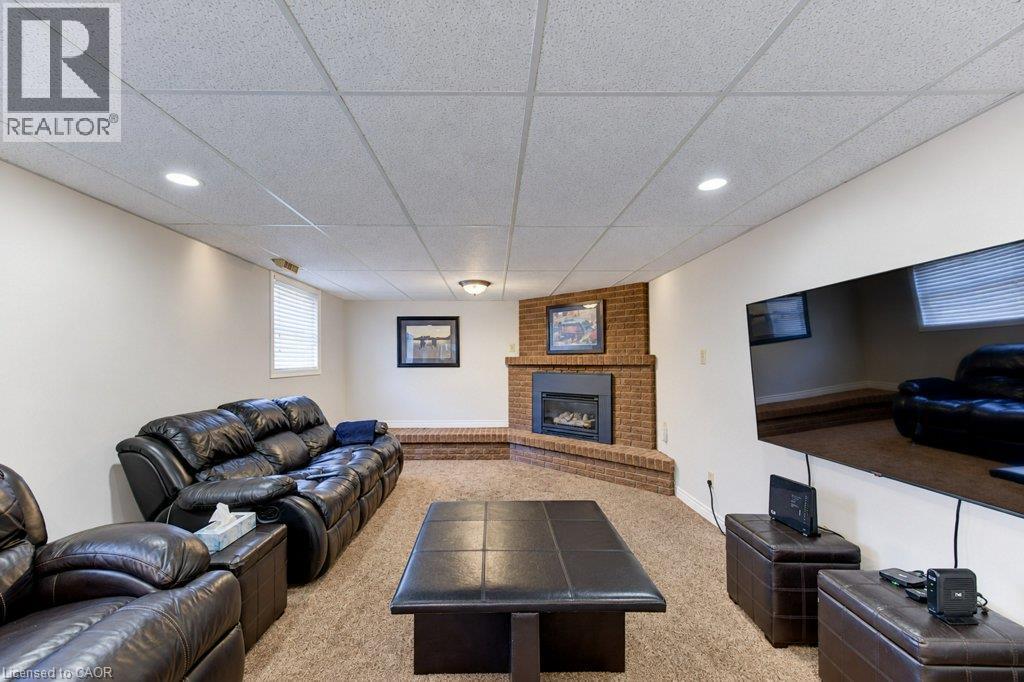 Corner brick-finish gas fireplace with hearth, recessed lighting, and drop ceiling - 34 Wayne Drive, Kitchener, ON
