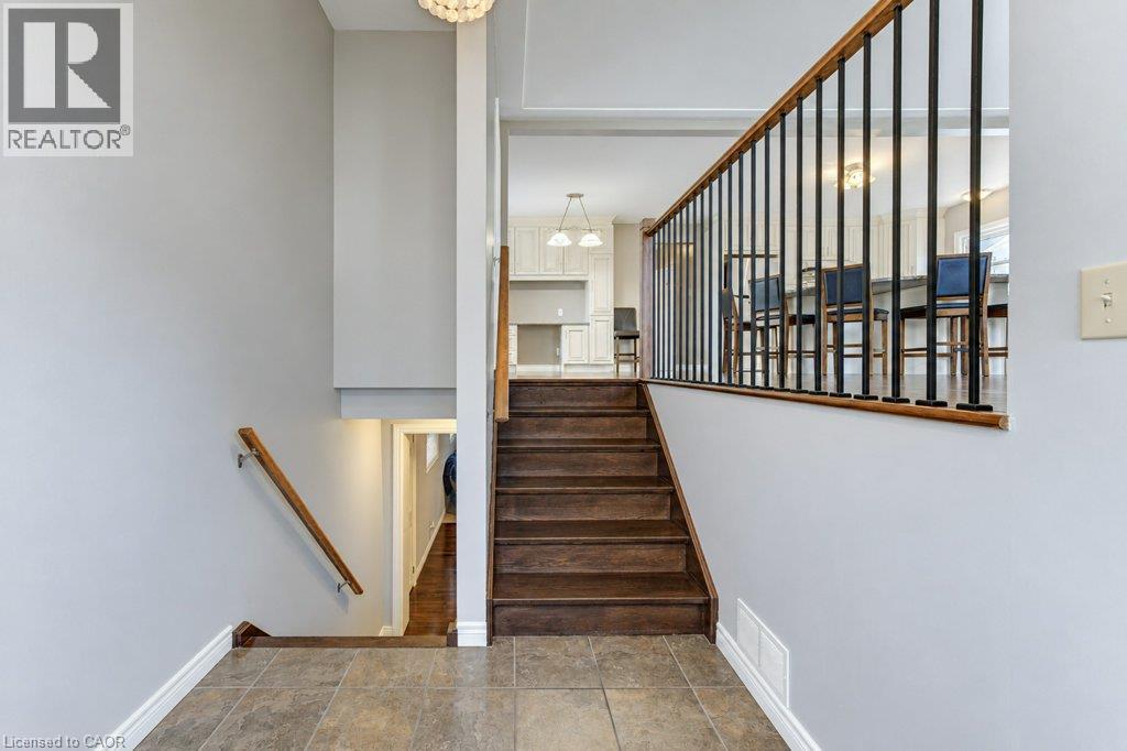 Entryway with tile flooring, wood-finish stairs, and metal balusters - 34 Wayne Drive, Kitchener, ON