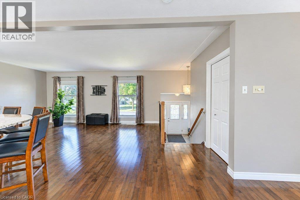 Hardwood flooring throughout, multiple windows, a white paneled entry door, and recessed lighting - 34 Wayne Drive, Kitchener, ON