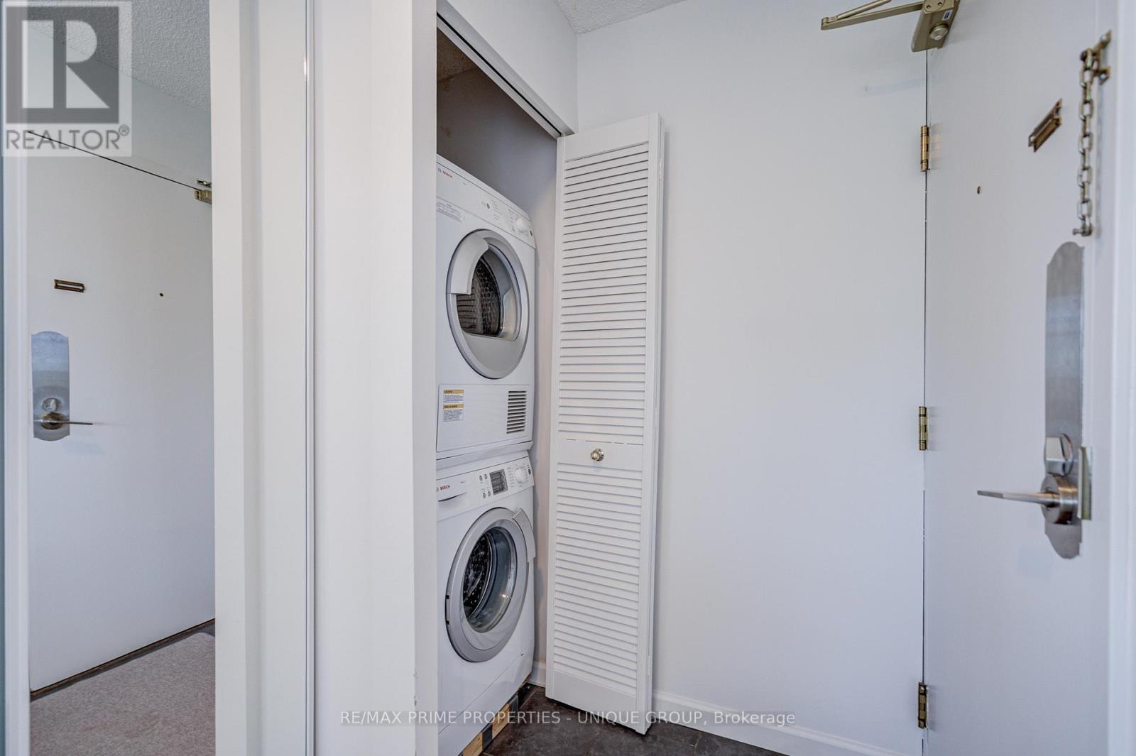 Stacked washer and dryer by entrance door. - 301 - 250 Queens Quay W, Toronto, ON
