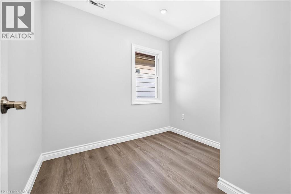 Recessed ceiling lighting, wood-finish flooring, white trim, and a white-framed window - 4 Albemarle Street, Hamilton, ON