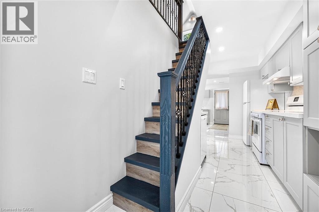 Staircase featuring wood-finish treads and wrought iron balusters - 4 Albemarle Street, Hamilton, ON
