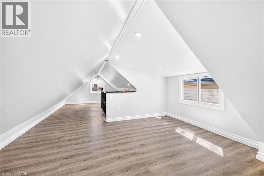Sloped ceilings with recessed lighting, wood-finish flooring, and white trim - 4 Albemarle Street, Hamilton, ON