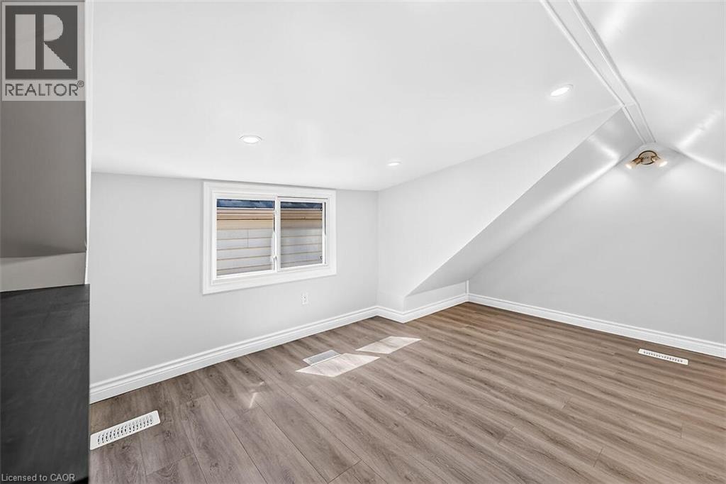 Wood-finish flooring, white walls, recessed lighting, white trim, and a window with white casing - 4 Albemarle Street, Hamilton, ON