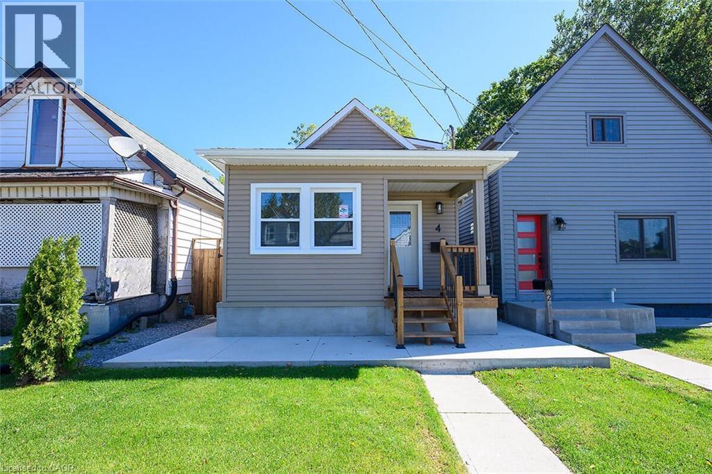 Taupe horizontal siding with white trim, a covered porch with natural wood stairs, and a concrete walkway - 4 Albemarle Street, Hamilton, ON