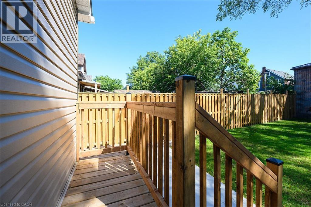 Outdoor deck with wood railing, leading to a private backyard - 4 Albemarle Street, Hamilton, ON