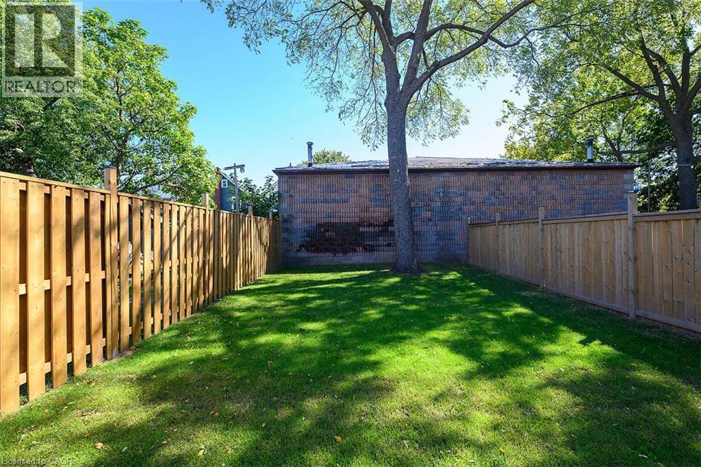 Expansive green lawn with established trees and full privacy fencing - 4 Albemarle Street, Hamilton, ON