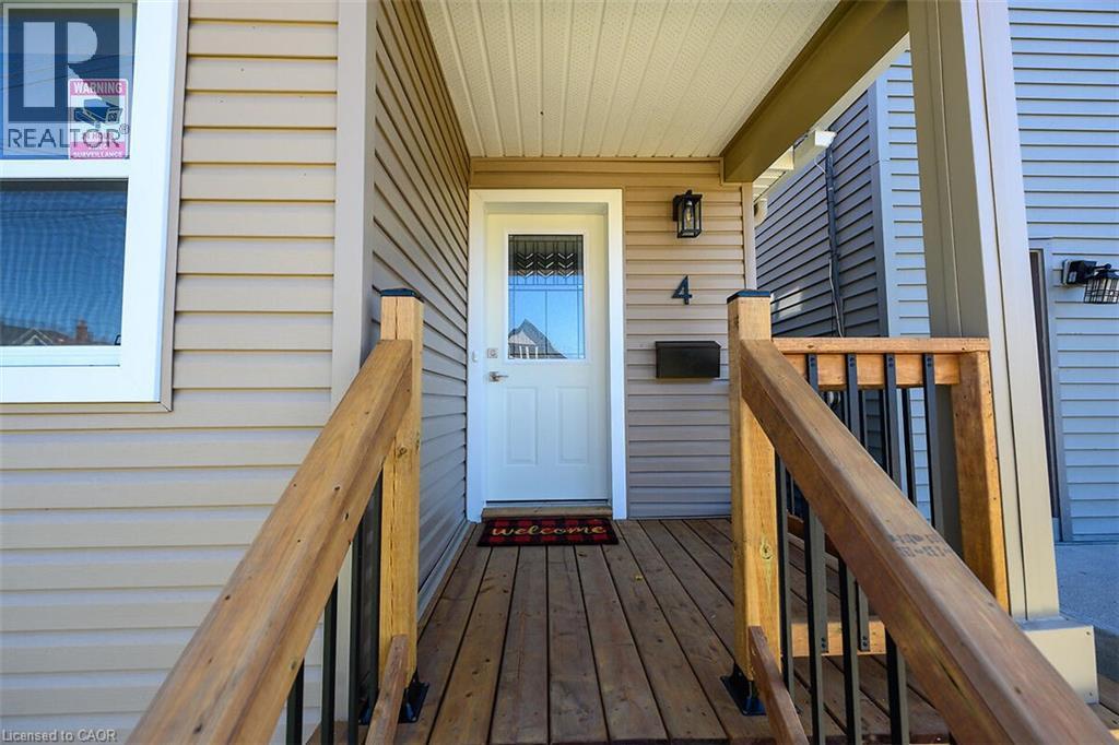 Covered front porch with wood-finish decking and natural wood railings - 4 Albemarle Street, Hamilton, ON