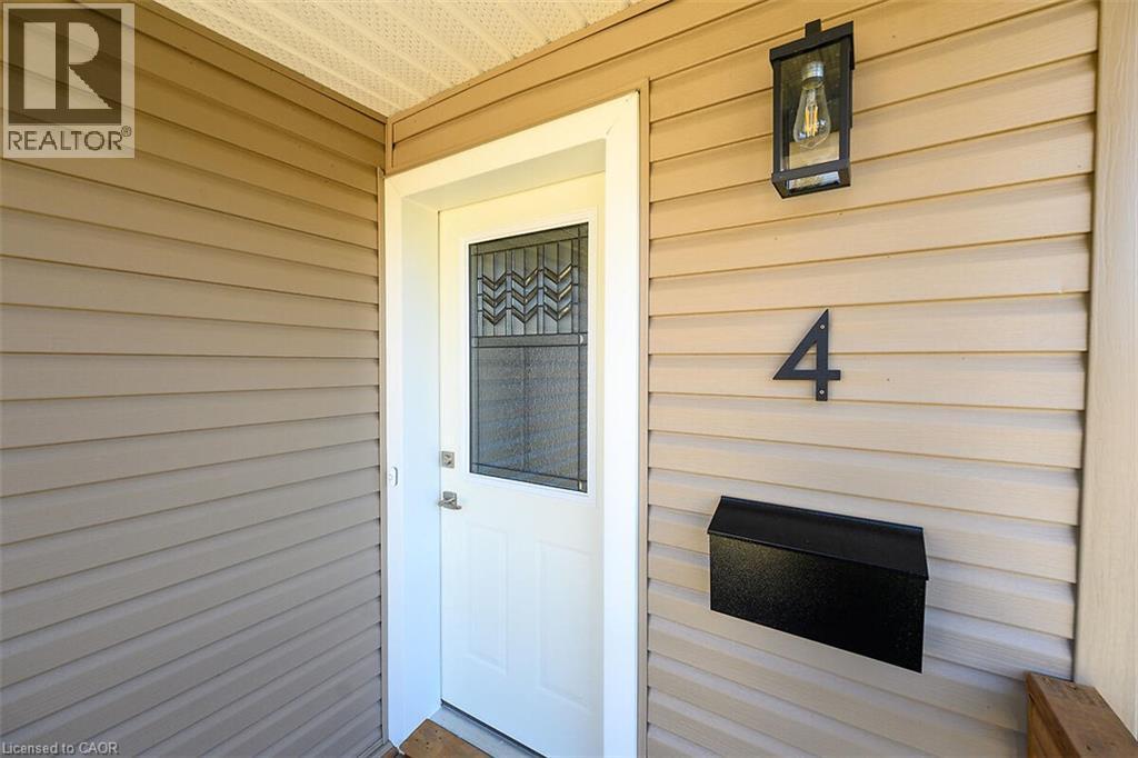 Entry door with decorative glass insert, metal wall-mounted mailbox, and exterior wall lantern - 4 Albemarle Street, Hamilton, ON
