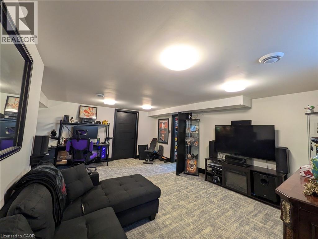 Recessed lighting, wood-finish flooring, and a built-in media console with an electric fireplace - 487 Scholfield Avenue N, Welland, ON