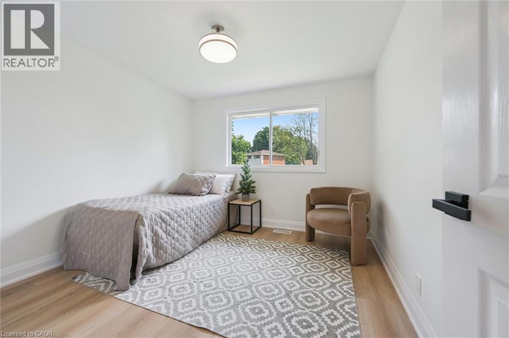 Bright interior room featuring a window overlooking greenery, light-toned wood-finish flooring, and a flush mount ceiling light - 299 Dale Crescent, Waterloo, ON