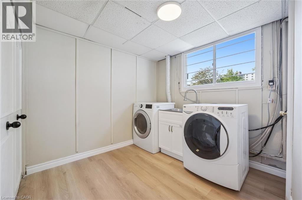 Dedicated laundry area featuring wood-finish flooring and a drop ceiling - 299 Dale Crescent, Waterloo, ON