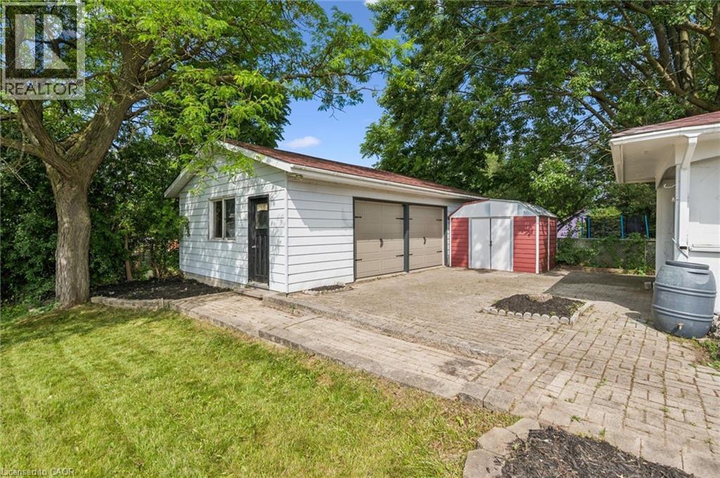 Detached garage with two roll-up doors, white siding, and a brown roof - 299 Dale Crescent, Waterloo, ON
