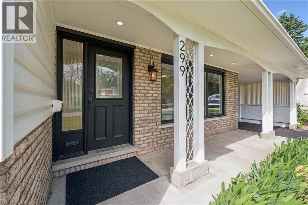 Covered front porch featuring brick facade, white siding, decorative white pillars, and a black entry door with leaded glass - 299 Dale Crescent, Waterloo, ON