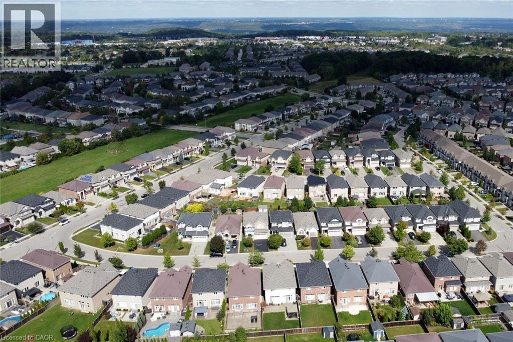 Residential properties featuring varied architectural styles, asphalt shingle roofs, and paved driveways - 25 Guest Street, Hamilton, ON