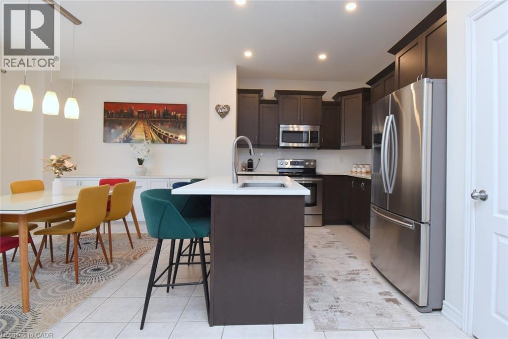Gourmet kitchen featuring dark wood cabinetry, stainless steel appliances, a center island with a white countertop, and recessed lighting - 25 Guest Street, Hamilton, ON