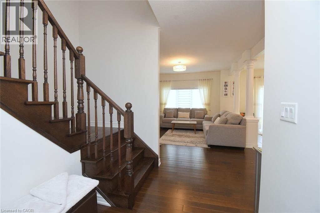Hardwood staircase with turned balusters, rich wood-finish flooring, and recessed lighting - 25 Guest Street, Hamilton, ON