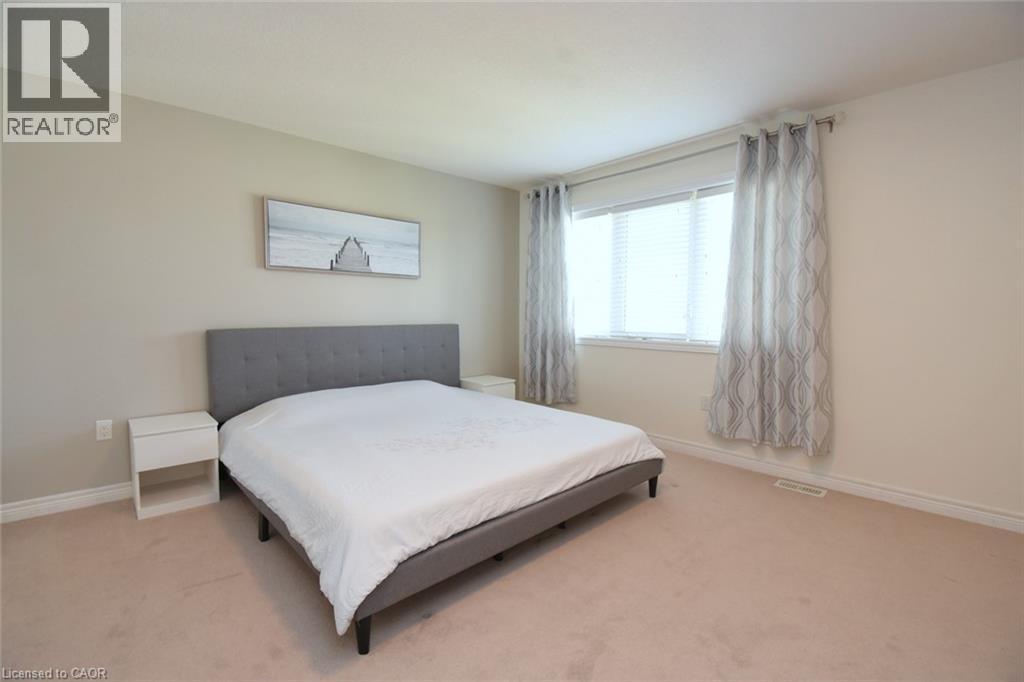 Neutral wall tones, window with horizontal blinds, and light-toned carpeting - 25 Guest Street, Hamilton, ON