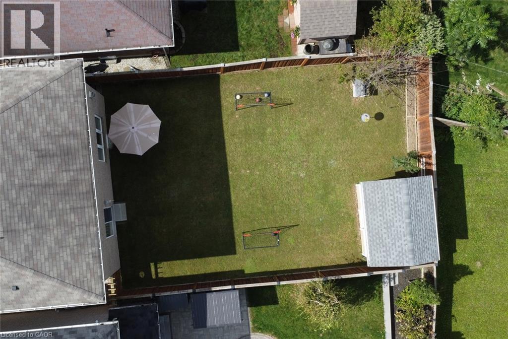 Fenced backyard featuring a detached shed and a green lawn - 25 Guest Street, Hamilton, ON