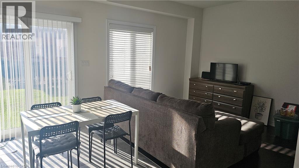 White walls, dark wood-finish flooring, sliding glass door with vertical blinds, window with horizontal blinds - 3 Sharp Drive, Ancaster, ON