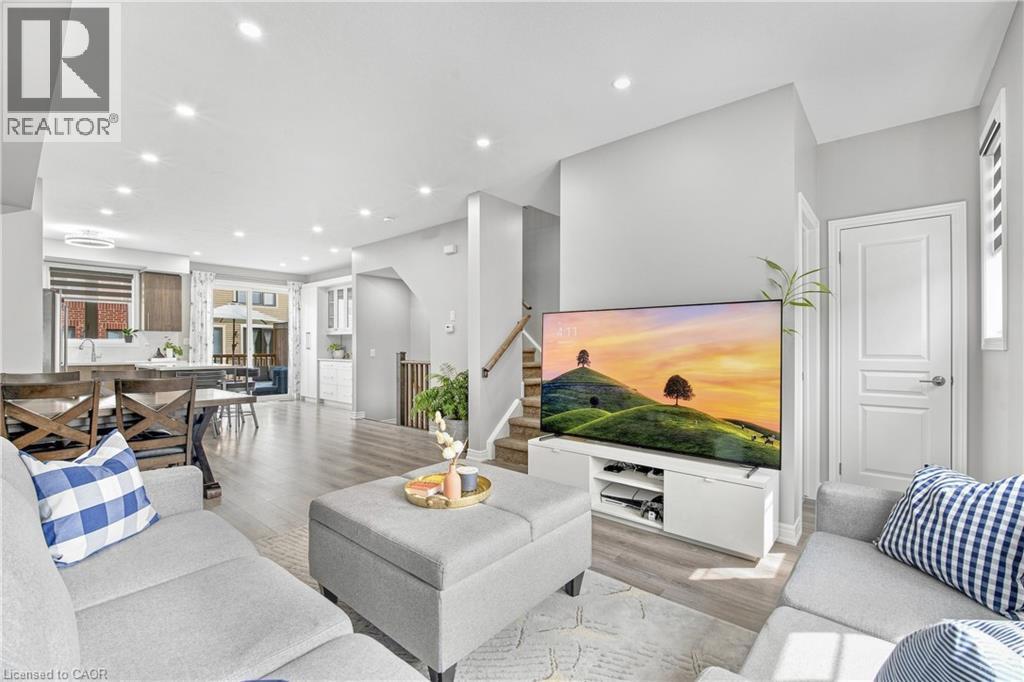 Open-concept living area with recessed lighting, wood-finish flooring, and light gray wall tones - 1890 Rymal Road E Unit# 144, Hamilton, ON