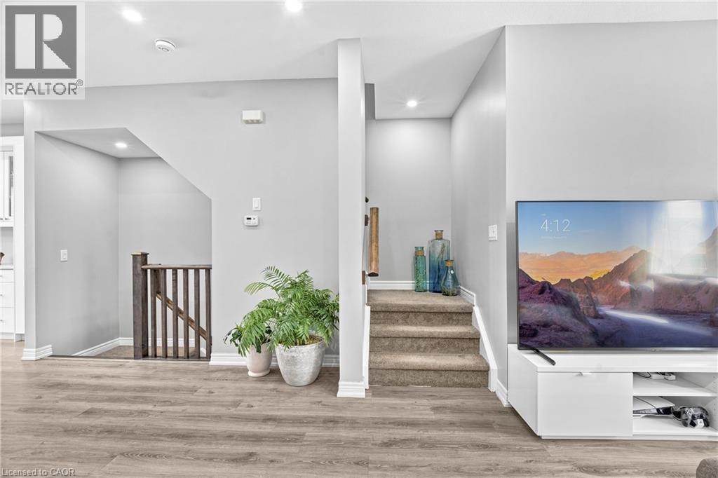 Wood-finish flooring and light gray wall tones create a neutral palette - 1890 Rymal Road E Unit# 144, Hamilton, ON