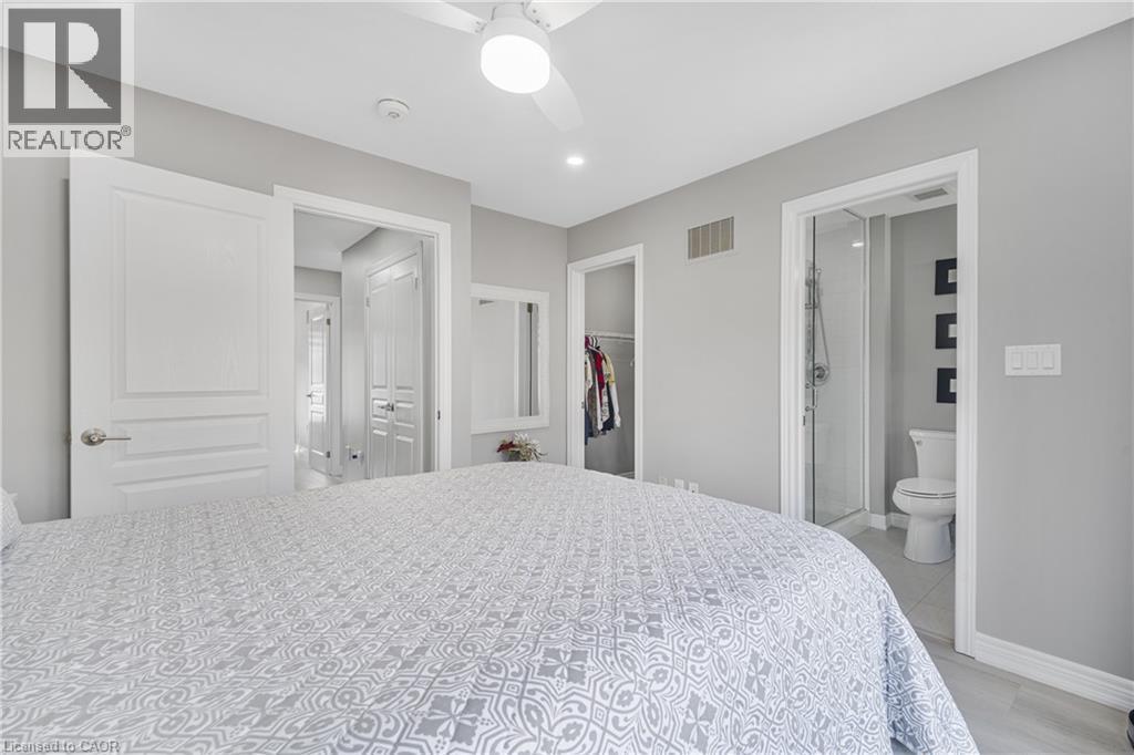 Recessed lighting, ceiling fan with integrated light, a walk-in closet, and a three-piece bathroom with a glass-enclosed shower - 1890 Rymal Road E Unit# 144, Hamilton, ON