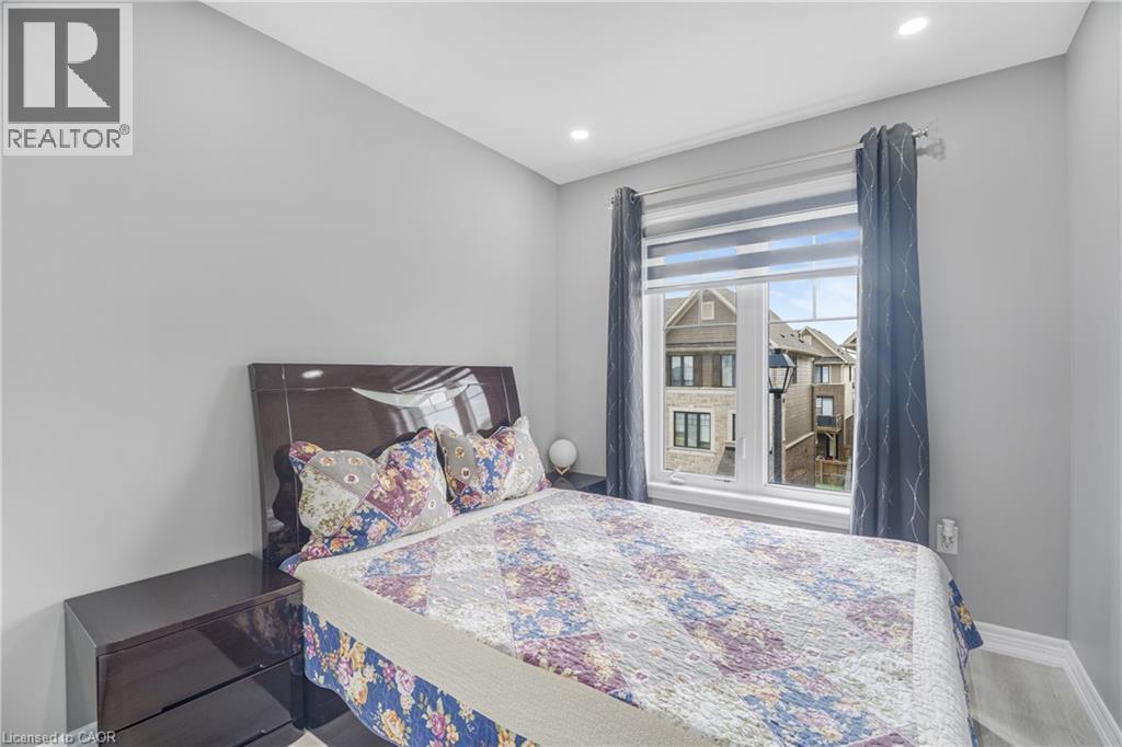Recessed lighting, wood-finish flooring, and a large window with roller shades - 1890 Rymal Road E Unit# 144, Hamilton, ON