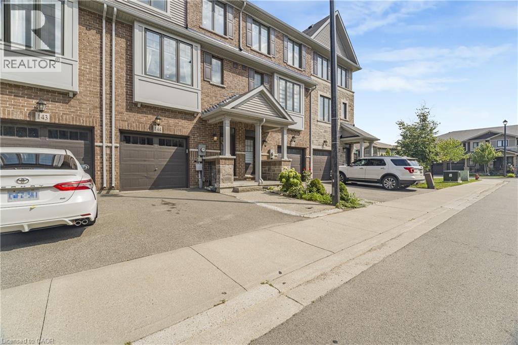 Brick townhouse exterior with multiple windows - 1890 Rymal Road E Unit# 144, Hamilton, ON
