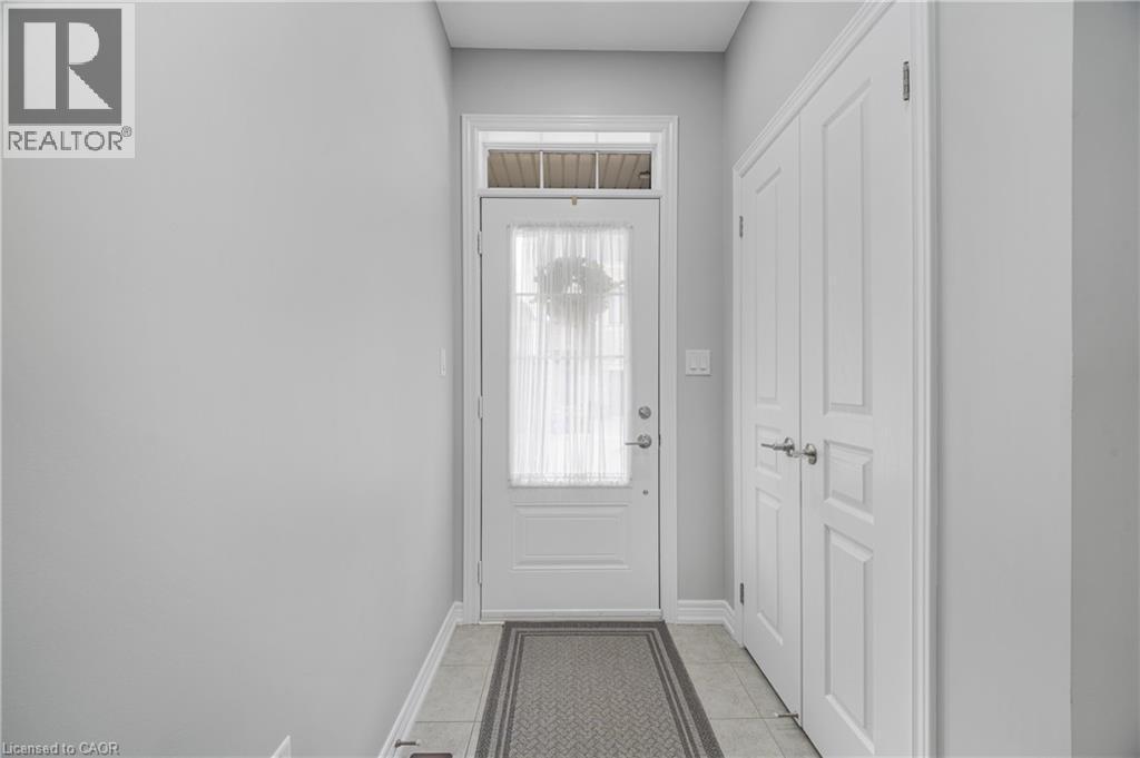Entryway featuring a panel door with transom window, tile flooring, and double bi-fold panel doors - 1890 Rymal Road E Unit# 144, Hamilton, ON