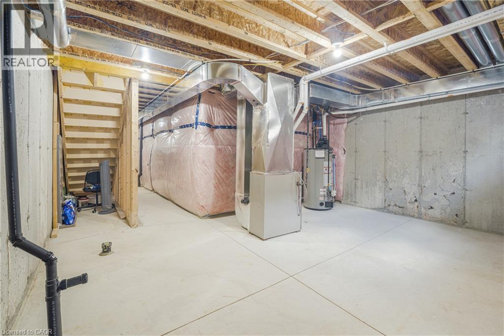 Unfinished basement with concrete flooring, exposed wood joists, and utility access - 1890 Rymal Road E Unit# 144, Hamilton, ON