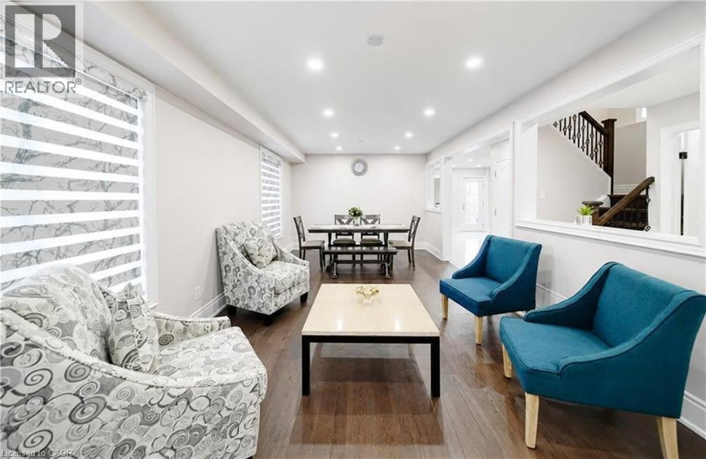 Open-concept living area with dark wood-finish flooring, recessed lighting, and a dining space - 643 Doon South Drive, Kitchener, ON
