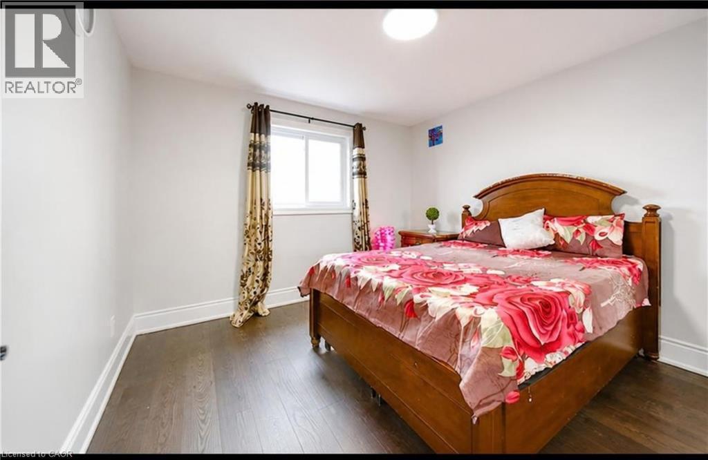 Wood-finish flooring, white painted walls, single window with roller shade, overhead dome light fixture, and crown molding - 643 Doon South Drive, Kitchener, ON