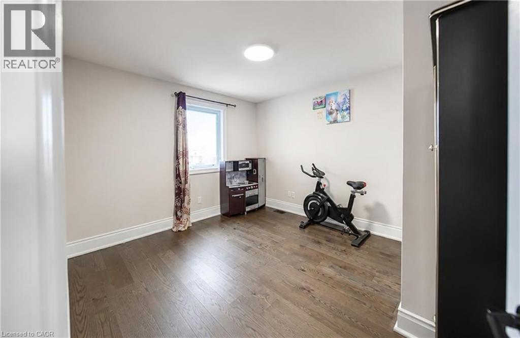 Hardwood flooring, white trim, recessed lighting, and a window for natural illumination - 643 Doon South Drive, Kitchener, ON