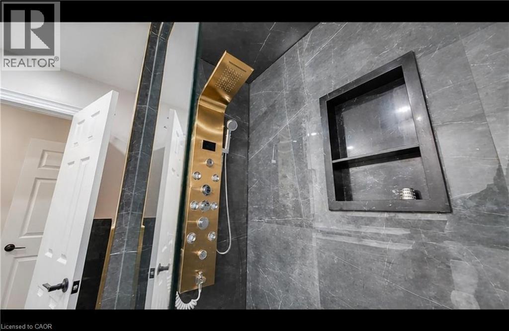 Modern gold-tone shower panel with multiple spray settings and handheld sprayer - 643 Doon South Drive, Kitchener, ON