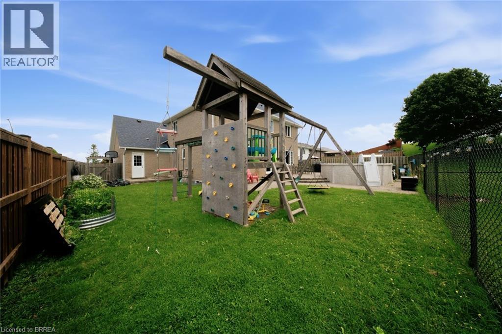 Expansive backyard featuring a manicured lawn, wood fencing, chain-link fencing, an above-ground pool, and a storage shed - 61 Sunnyside Drive, St. George, ON